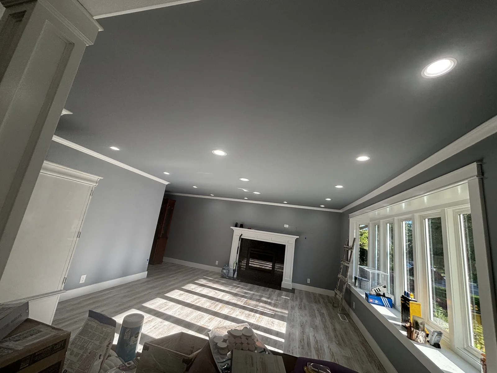 Open living room with fireplace and a layout of recessed ceiling lights