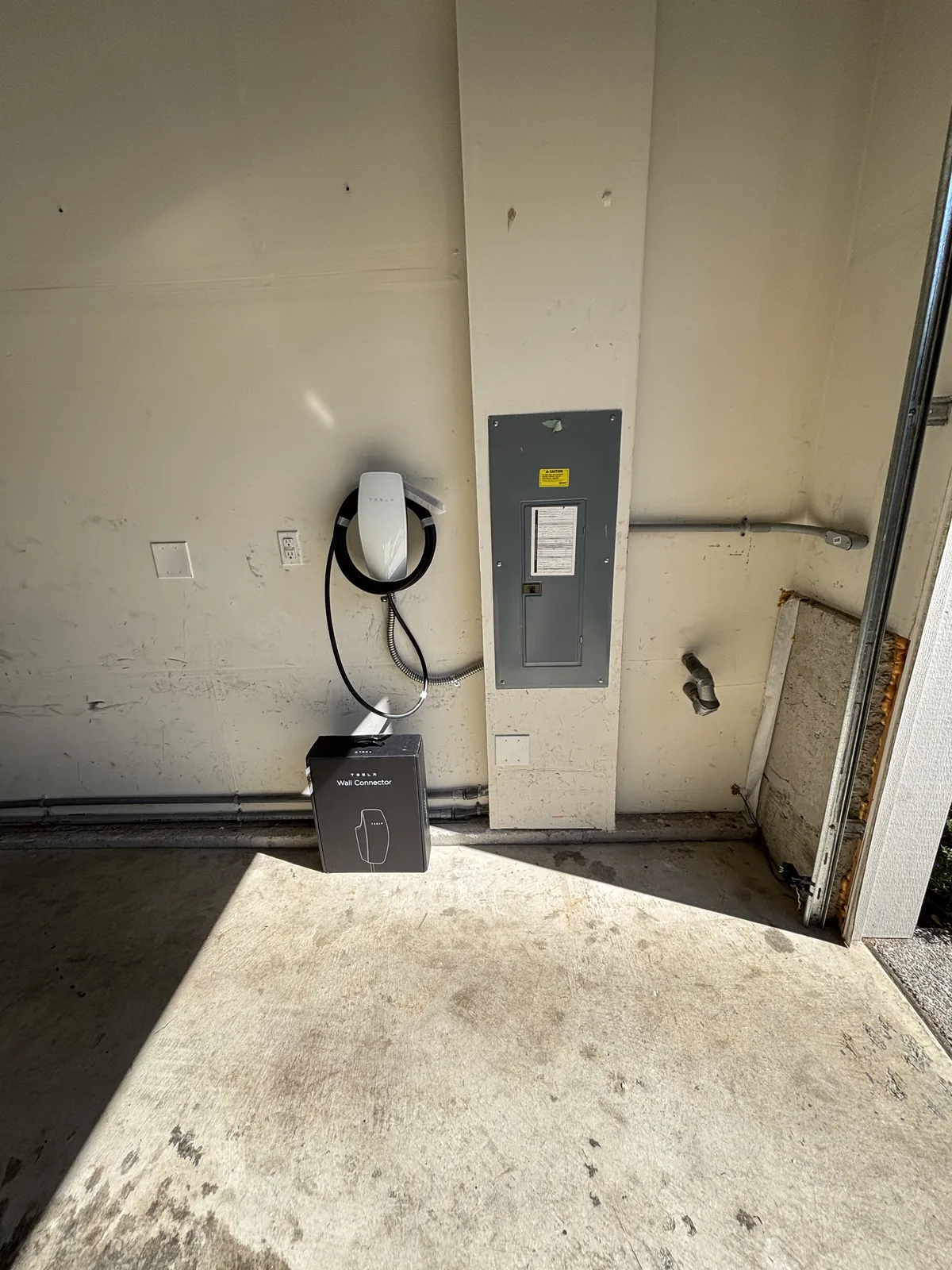Tesla Wall Connector and electrical panel in a garage during installation