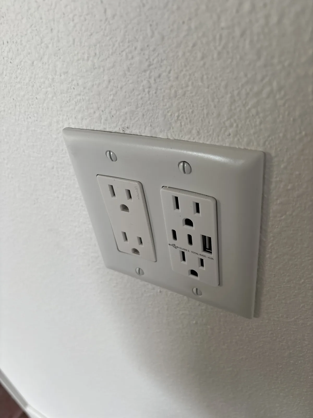 Combination duplex receptacle with built-in USB charging ports in a wall
