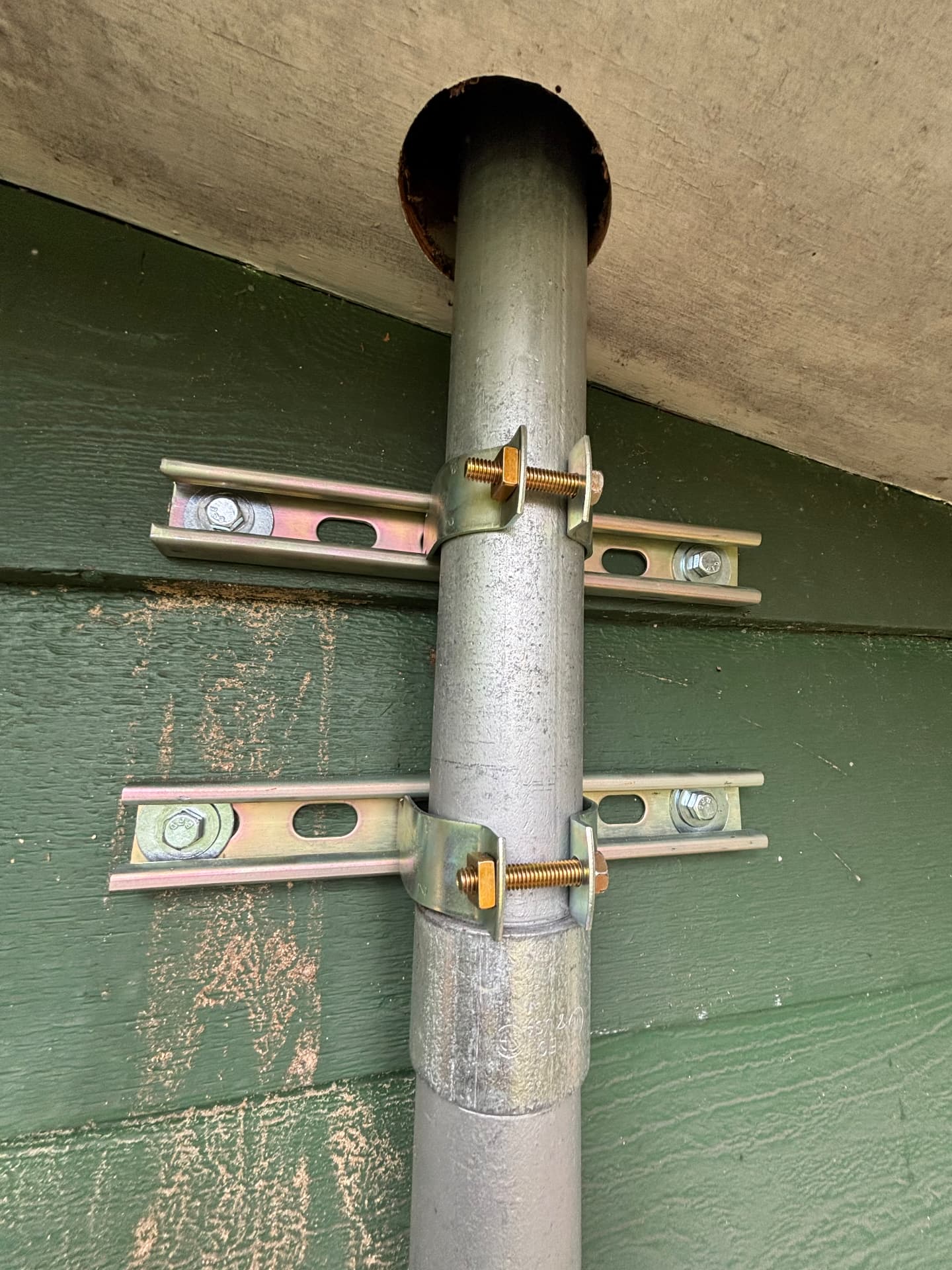 Exterior metal conduit secured to strut with two conduit clamps