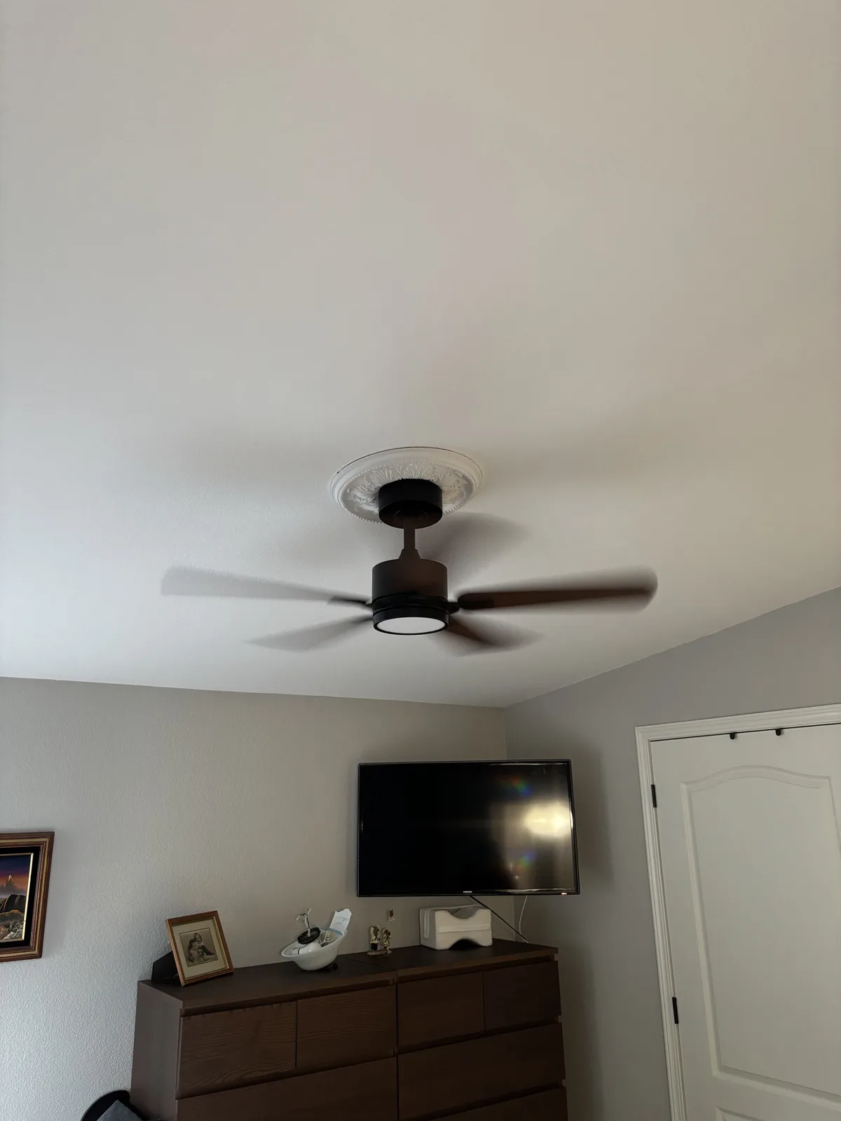 Bedroom ceiling fan with an integrated light above a dresser