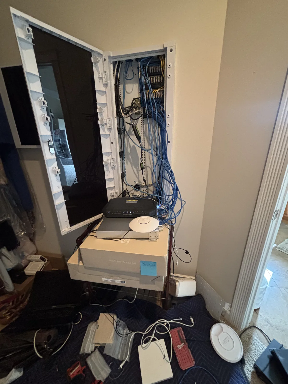 Open structured-wiring enclosure with network equipment and cables during installation