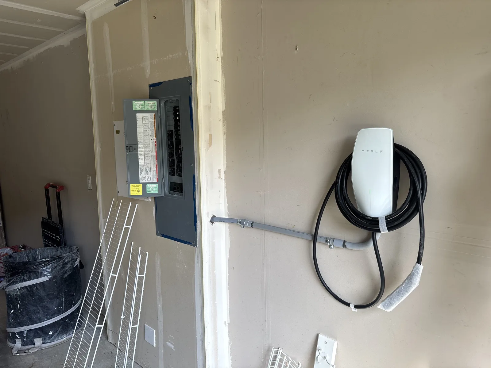 Tesla Wall Connector with the charging cable coiled on its holder